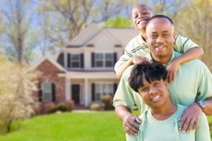 Family in front of their home. More middle class families are utilizing bankruptcy in order to get out from the financial stress caused by the pandemic.