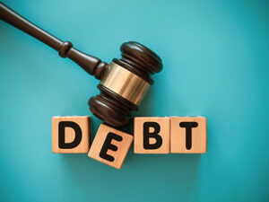 Gavel on top of wooden blocks that spell out "debt."