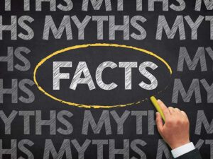 The word "facts" circled on a chalkboard with "myths" written all around it.
