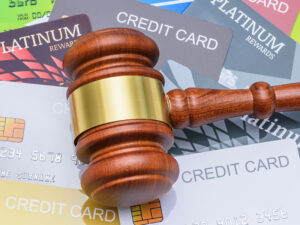 Gavel laying on top of multiple credit cards.